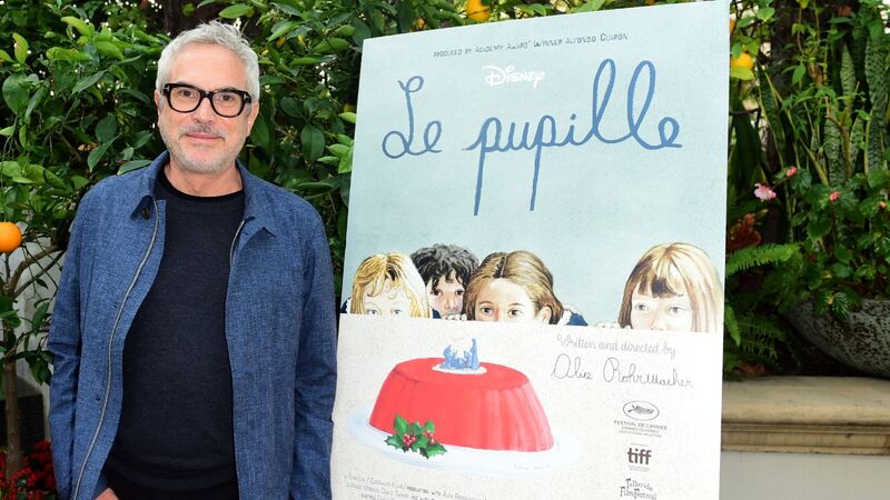 Foto: Alfonso Cuarón e cartaz de Le Pupille - (Crédito: Vivien Killilea/Getty Images for Disney)