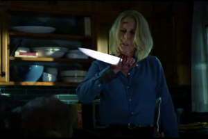Atriz Jamie Lee Curtis no papel de Laurie Strood segurando e olhando para uma faca.