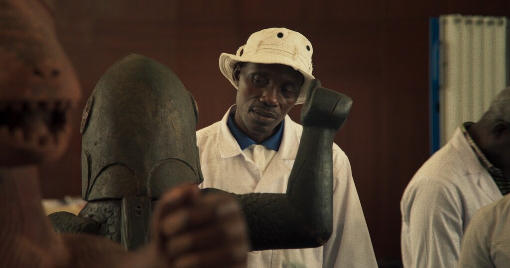 homem de blusa branca e chapeu no filme dahomey, que chega em dezembro na mubi