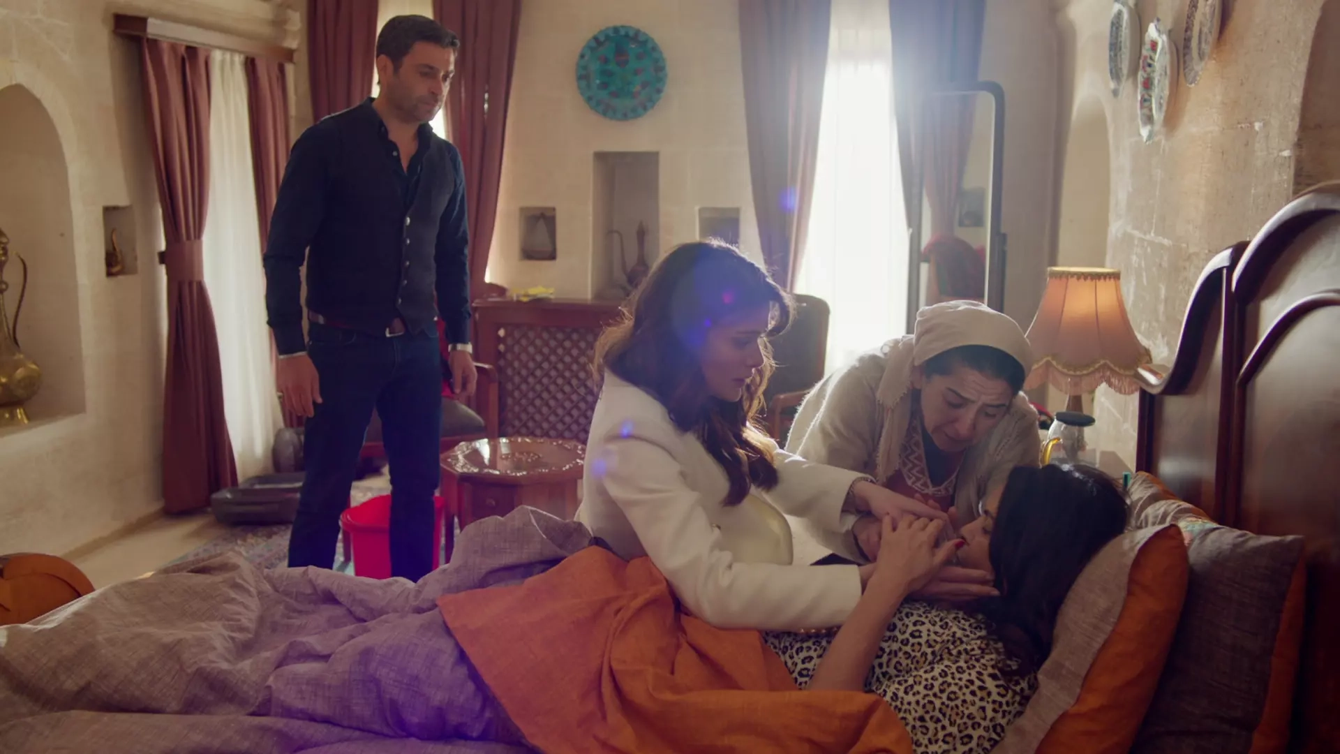 A imagem mostra a atriz turca Nursel Köse deitada em cena de Uzak Şehir, novela turca