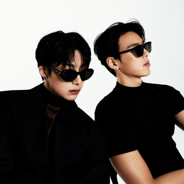 Integrantes Shownu e Hyungwon do MONSTA X usando roupas pretas e óculos escuros