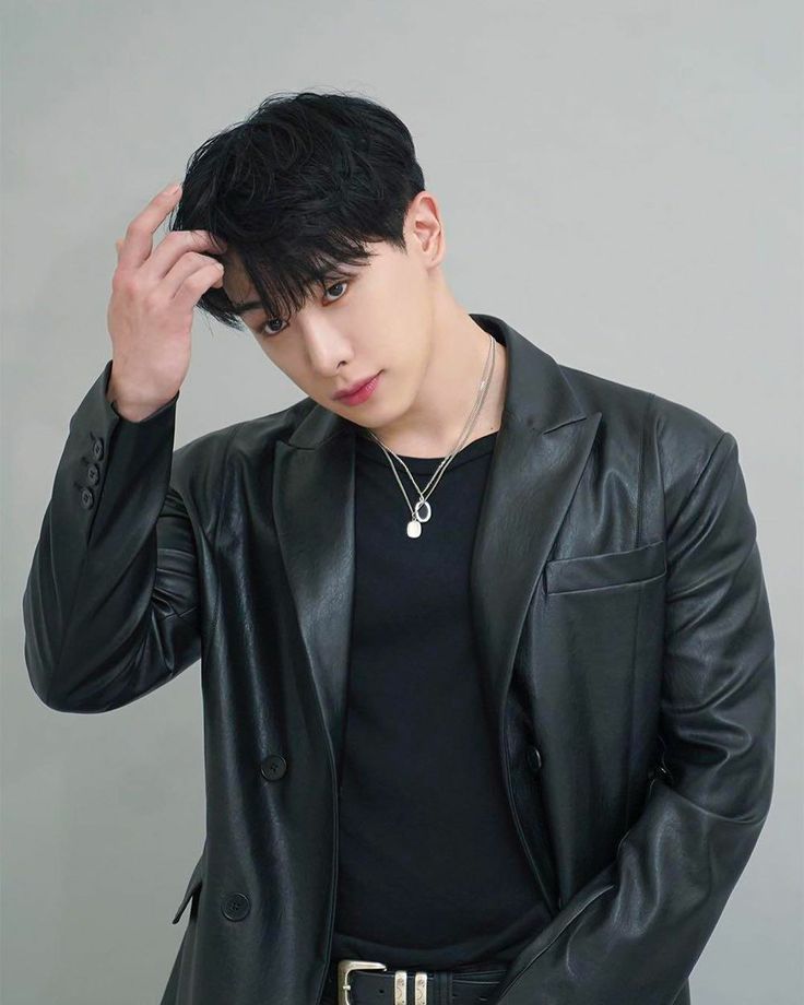 Ex-integrante MONSTA X Wonho vestindo roupas pretas e com a mão no cabelo