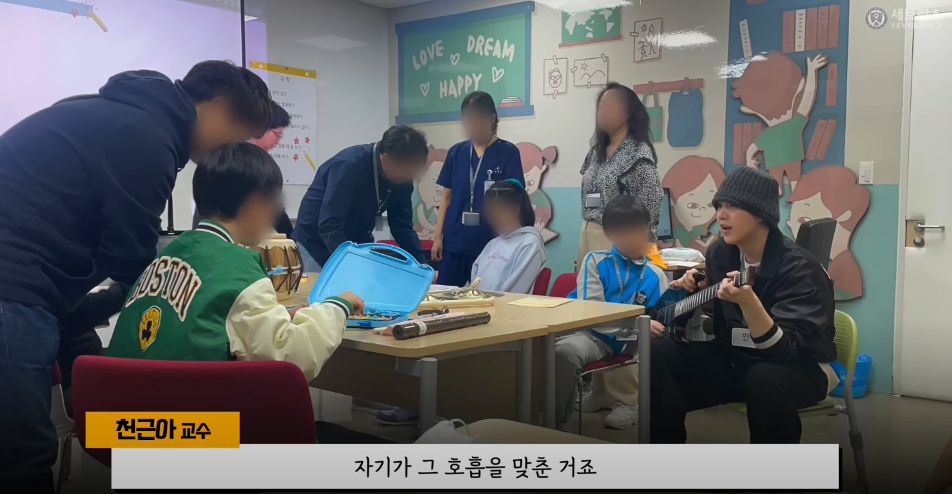 Suga tocando instrumentos com as crianças do centro de tratamento