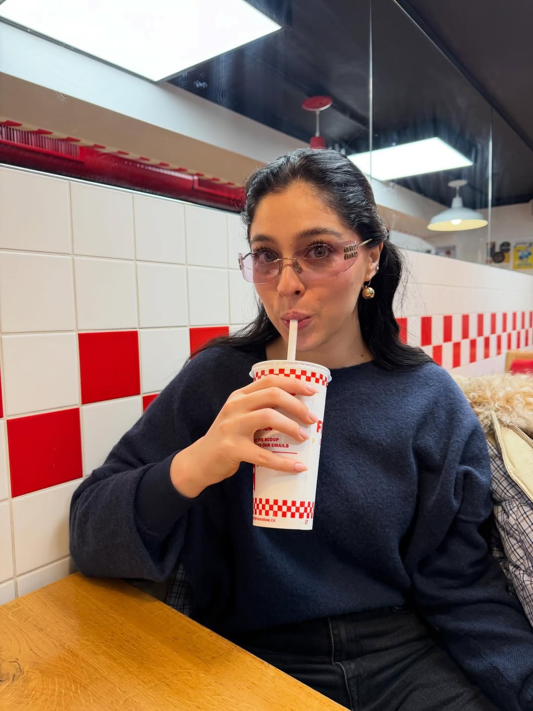 Cemre Baysel tomando suco em uma lanchonete