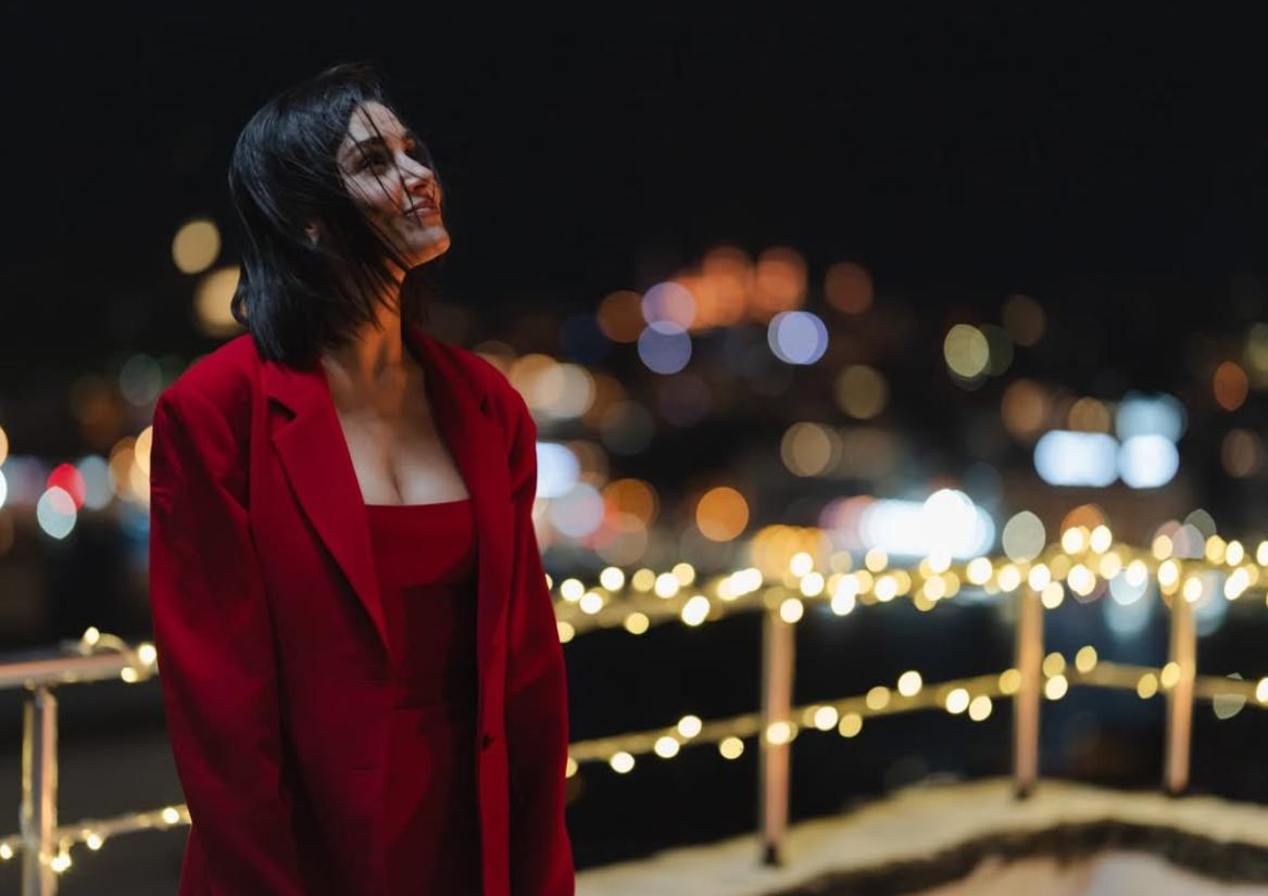 Hande Erçel sorrindo, olhando para cima, no filme Dois Mundos, Um Desejo