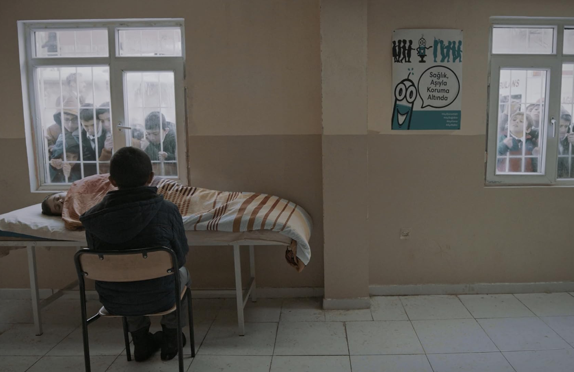 Samet Yildiz sentado na frente de Nurullah Alaca, em cena de O Protetor do Irmão