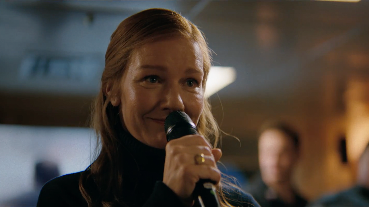 Sandra Hüller cantando com microfone na mão