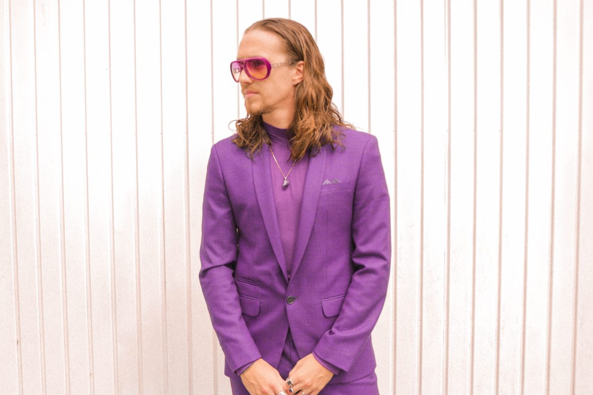 vitor kley de terno roxo e óculos rosa