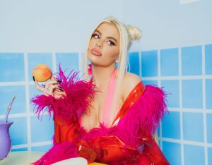 Take de CAFÉ DA MANHÃ ;P, parte do novo álbum, onde Luísa aparece com uma roupa vermelha e rosa, segurando uma pêra