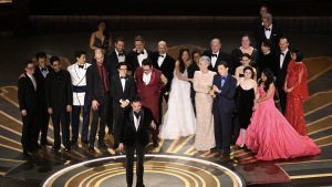 Elenco de Tudo em Todo o Lugar ao Mesmo Tempo recebendo o troféu de Melhor Filme no Oscar 2023
