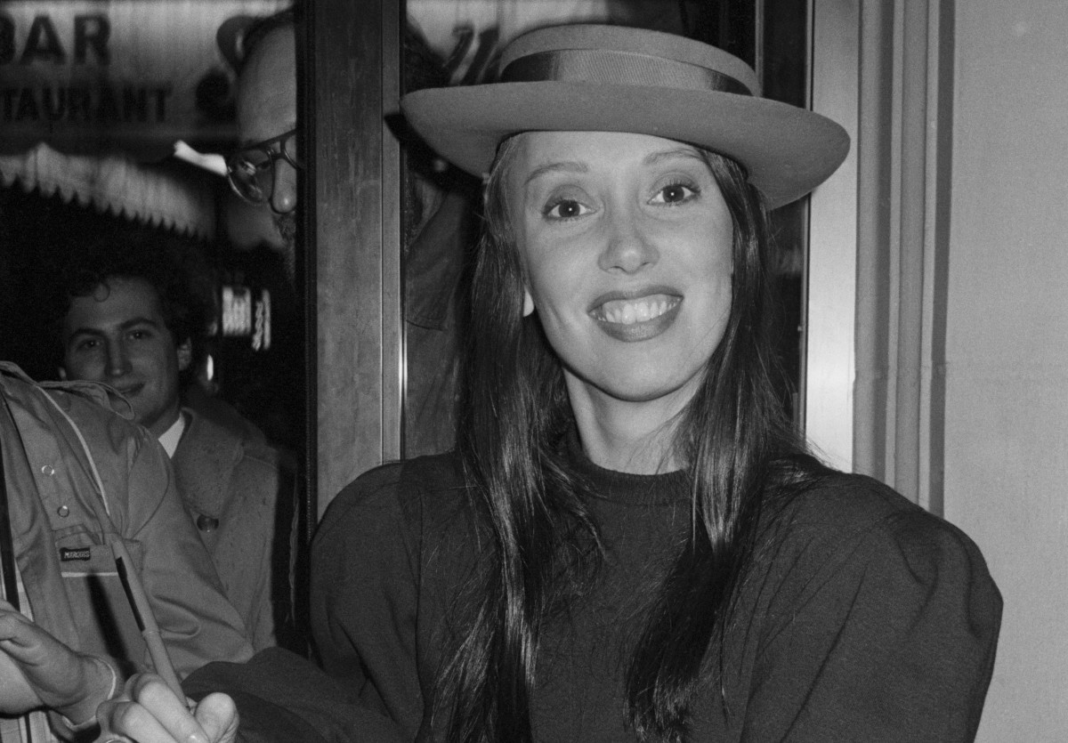 A atriz Shelley Duvall sorrindo para foto enquanto jovem, em fotografia preto e branco.