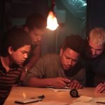 Quatro protagonistas do filme passagrana analisando um papel