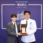 Suga recebendo placa de reconhecimento do Hospital Severance