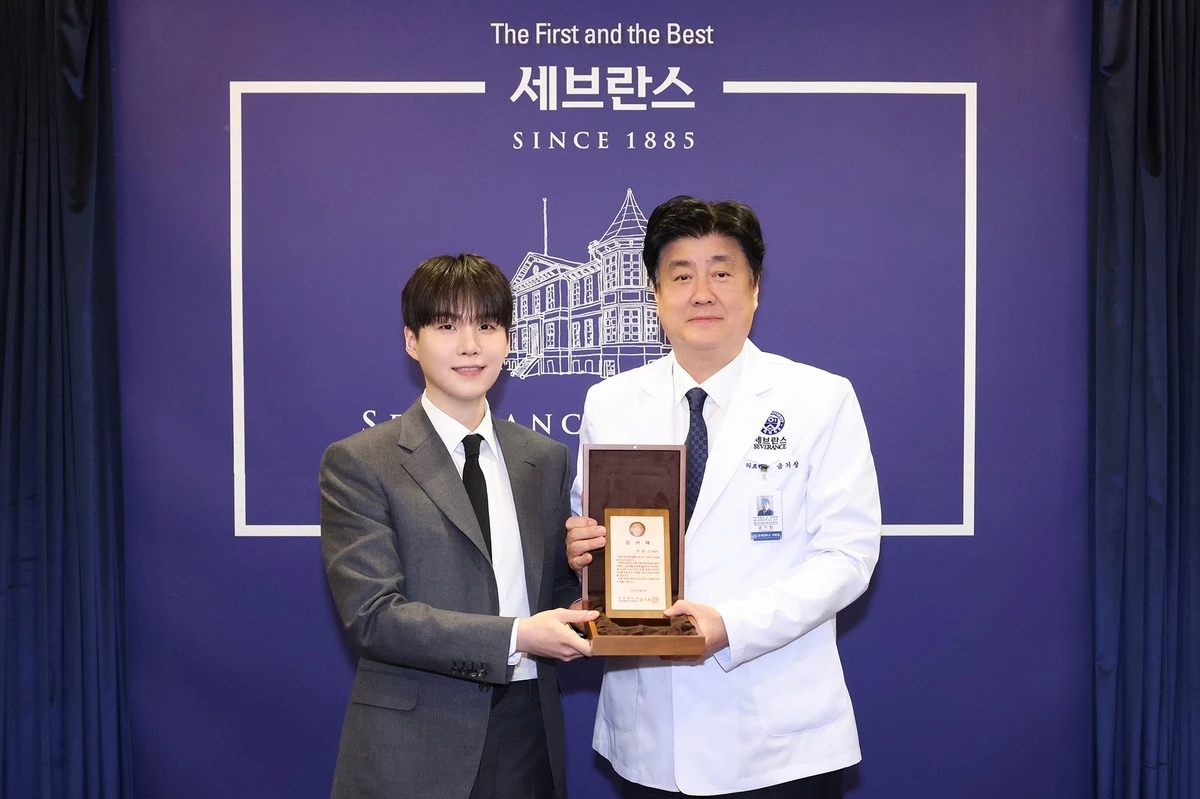 Suga recebendo placa de reconhecimento do Hospital Severance