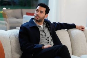 Murat Yıldırım, ator turco, sentado em um sofá em cena de Güller Ve Günahlar
