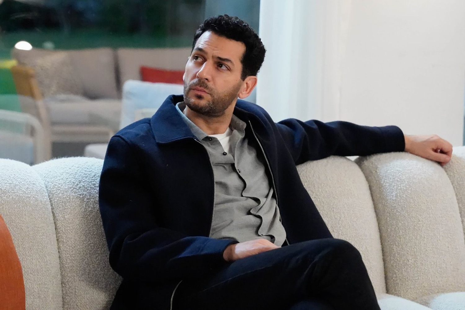 Murat Yıldırım, ator turco, sentado em um sofá em cena de Güller Ve Günahlar