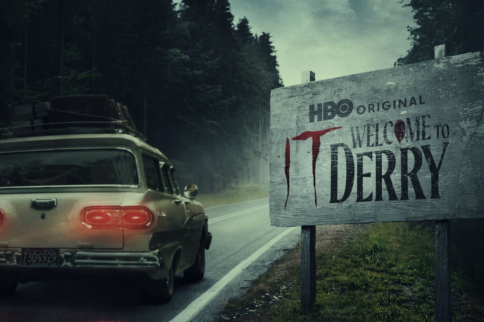 Carro passando por uma placa escrito "Bem vindos a Derry".
