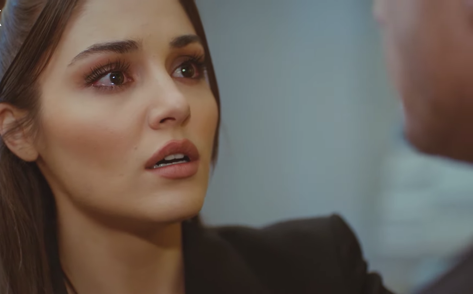 Hande Ercel com cabelos castanhos olha emocionada para personagem em Será Isso Amor?