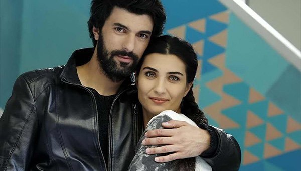 Engin Akyürek e Tuba Büyüküstün posam abraçados durante uma cena da novela Kara Para Aşk.