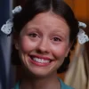 Personagem Pearl com zoom em seu rosto e sorriso apreensivo.