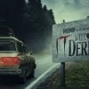 Carro passando por uma placa escrito "Bem vindos a Derry".