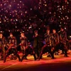 Vamos ser sinceros: por que sempre que os fãs latino-americanos reclamam de alguma coisa relacionada aos shows aparece alguém para dizer que eles deveriam agradecer pela oportunidade de ver o BTS? Parece que, para uma parte do fandom, morar na América Latina (América do Sul) significa ter que aceitar qualquer condição sem reclamar, como se receber uma turnê já fosse motivo suficiente para ficar quieto. E não, não é bem assim que funciona. É claro que organizar shows em diferentes países não é tão simples quanto parece. Existem diferenças de estrutura, logística, custos e várias outras questões que influenciam a produção de uma turnê. Ninguém está dizendo que todos os países precisam receber exatamente o mesmo palco ou que tudo funciona da mesma maneira em qualquer lugar. Mas reconhecer essas dificuldades é bem diferente de usar isso como argumento para invalidar toda reclamação dos fãs latinos. Afinal, por que alguém que compra um ingresso na América Latina deveria ter menos liberdade para questionar a experiência que está pagando para viver? Um fã brasileiro, mexicano, chileno ou argentino não precisa provar que ama o BTS tanto quanto alguém dos Estados Unidos, da Europa ou da Coreia do Sul. Também não precisa mostrar quantos streams fez, quantos álbuns comprou ou quantas metas ajudou a bater para ter o direito de dizer que alguma coisa poderia ser melhor. Desde quando ser fã significa aceitar tudo sem reclamar? Essa é uma das coisas mais cansativas nessa discussão. Às vezes, parece que o ARMY latino precisa apresentar uma lista de tudo o que já fez pelo grupo antes de poder falar sobre qualquer problema. E, quando finalmente reclama, ainda corre o risco de ser chamado de ingrato, como se apontar algo que incomoda fosse o mesmo que não valorizar a presença do BTS na região. Mas dá para estar feliz com a possibilidade de ver os meninos e, ao mesmo tempo, querer uma organização melhor. Dá para esperar anos por um show, juntar dinheiro para comprar o ingresso e ainda questionar decisões que afetam a experiência do público. Uma coisa não anula a outra, e os fãs não deveriam precisar escolher entre demonstrar amor pelo grupo e expressar a própria insatisfação. E as produtoras ficam de fora dessa conversa? Não dá para falar sobre a experiência dos fãs sem falar das empresas responsáveis pelos shows. Sim, uma turnê internacional envolve muitas pessoas e nem todas as decisões dependem das produtoras locais, mas isso não significa que elas não devam ser questionadas sobre aquilo que está sob sua responsabilidade. Organização das filas, segurança, acessibilidade, visibilidade, informações sobre ingressos e comunicação com o público são questões importantes para quem vai a um evento. Se os fãs pagam por uma experiência, é justo que esperem informações claras e uma estrutura bem planejada. E, quando alguma coisa não sai como deveria, também é justo querer explicações. O problema é que, muitas vezes, a discussão sobre essas questões acaba virando uma briga entre os próprios fãs. Em vez de conversar sobre o que aconteceu e se existe algo que precisa ser melhorado, algumas pessoas preferem defender que a LATAM deveria aceitar as condições oferecidas porque, afinal, pelo menos o BTS vai estar lá. Mas gente, não é justamente esse o ponto? Os fãs estão felizes com a possibilidade de ver o grupo. O que eles questionam são as condições em que essa experiência acontece. Uma coisa é agradecer pela realização de um show e outra é achar que essa gratidão precisa vir acompanhada de silêncio diante de qualquer problema. E vale lembrar: nem toda diferença entre países significa que houve tratamento injusto. Cada situação precisa ser analisada, e é importante entender o que realmente aconteceu antes de tirar conclusões. Só que isso também vale para quem tenta desmerecer as reclamações. Não dá para decidir que os fãs estão exagerando antes mesmo de ouvir o que eles têm a dizer. O fandom é global, mas será que todo mundo se lembra disso? O BTS tem fãs espalhados pelo mundo inteiro e o ARMY adora falar sobre como essa comunidade consegue se unir por um objetivo em comum. A gente vê isso nos lançamentos, nos projetos, nas campanhas e em toda a mobilização que acontece quando o grupo tem alguma novidade. Mas, quando o assunto é a experiência dos fãs em diferentes países, parece que essa união nem sempre funciona tão bem. É complicado celebrar a força da LATAM quando o assunto são números e engajamento, mas desmerecer os fãs da região quando eles apontam alguma coisa que não gostaram. Se a participação latino-americana é motivo de orgulho para o fandom, por que as opiniões desses mesmos fãs seriam menos importantes? E não, isso não significa que todos os fãs de outros países pensem assim. Seria injusto colocar todo mundo no mesmo grupo, porque existem ARMYs de diferentes regiões que também defendem o respeito e entendem essas preocupações. A crítica é para quem transforma qualquer comparação em uma competição e age como se alguns públicos tivessem mais direito de reclamar do que outros. Também não precisamos transformar isso em uma disputa entre a LATAM e os Estados Unidos, por exemplo. Os fãs norte-americanos não precisam perder nada para que os latino-americanos sejam respeitados. Ninguém está pedindo para diminuir a experiência de outra região, mas para que a nossa também possa ser discutida sem que toda conversa vire uma guerra. Defender o ARMY latino não é atacar os fãs de outros países. É pedir que a gente pare de tratar essas pessoas como se elas estivessem sempre exigindo demais. A LATAM só é valorizada quando os números são bons? Essa é outra questão que merece atenção. Quando falamos sobre o alcance do BTS, a participação dos fãs latino-americanos aparece como parte importante da dimensão global do grupo. São pessoas que acompanham os lançamentos, participam das atividades do fandom, divulgam o trabalho dos integrantes e movimentam comunidades inteiras. Mas essa valorização fica incompleta quando as preocupações desses mesmos fãs são tratadas como exagero. E tem outro detalhe: para muita gente, ir a um show do BTS não é algo simples. É preciso economizar durante meses, organizar transporte, pensar em hospedagem e conciliar o sonho de ver o grupo com as despesas do dia a dia. O ingresso é apenas uma parte dos gastos, e nem todo mundo tem as mesmas condições financeiras para fazer isso acontecer. Por isso, é tão frustrante quando alguém age como se os fãs devessem aceitar qualquer experiência só porque tiveram a oportunidade de comprar um ingresso. A gente está falando de pessoas que se planejam, fazem sacrifícios e esperam viver um momento importante. É natural que elas queiram que tudo funcione da melhor maneira possível. E será que pedir isso é realmente exigir demais? Não significa esperar que todos os países recebam produções idênticas ou ignorar as dificuldades envolvidas em uma turnê. Significa entender que os fãs também fazem parte dessa experiência e que suas opiniões não deveriam ser descartadas só porque vêm de determinada região. No fim das contas, o ARMY latino não precisa provar que ama o BTS para ter o direito de reclamar de um show. Não precisa competir com fãs de outros países para merecer atenção, muito menos aceitar que qualquer questionamento seja interpretado como falta de gratidão. As produtoras precisam responder pelo que está sob sua responsabilidade, e o fandom precisa entender que defender melhores condições para uma região não significa atacar outra. Parece simples, mas essa diferença faz toda a diferença na maneira como essa conversa acontece. Porque, vamos combinar, ninguém deveria precisar passar mais tempo defendendo o próprio direito de reclamar do que discutindo o problema que realmente importa. Se o BTS tem uma comunidade global, por que ainda existe tanta resistência quando os fãs latino-americanos pedem para ser ouvidos? Qual a sua opinião sobre isso? Compartilha com a gente nas redes sociais do Entretetizei (Facebook, Instagram e X) e nos siga para não perder nenhuma novidade do K-pop! BTS